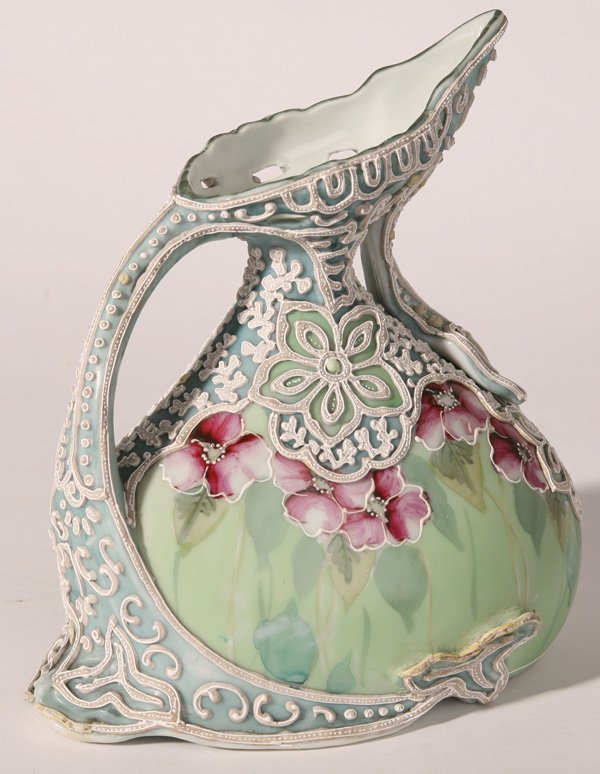 NIPPON MORIAGE EWER: Great decoration over handpainted violets. Some loss near base on each side, otherwise fine condition. 8" h.