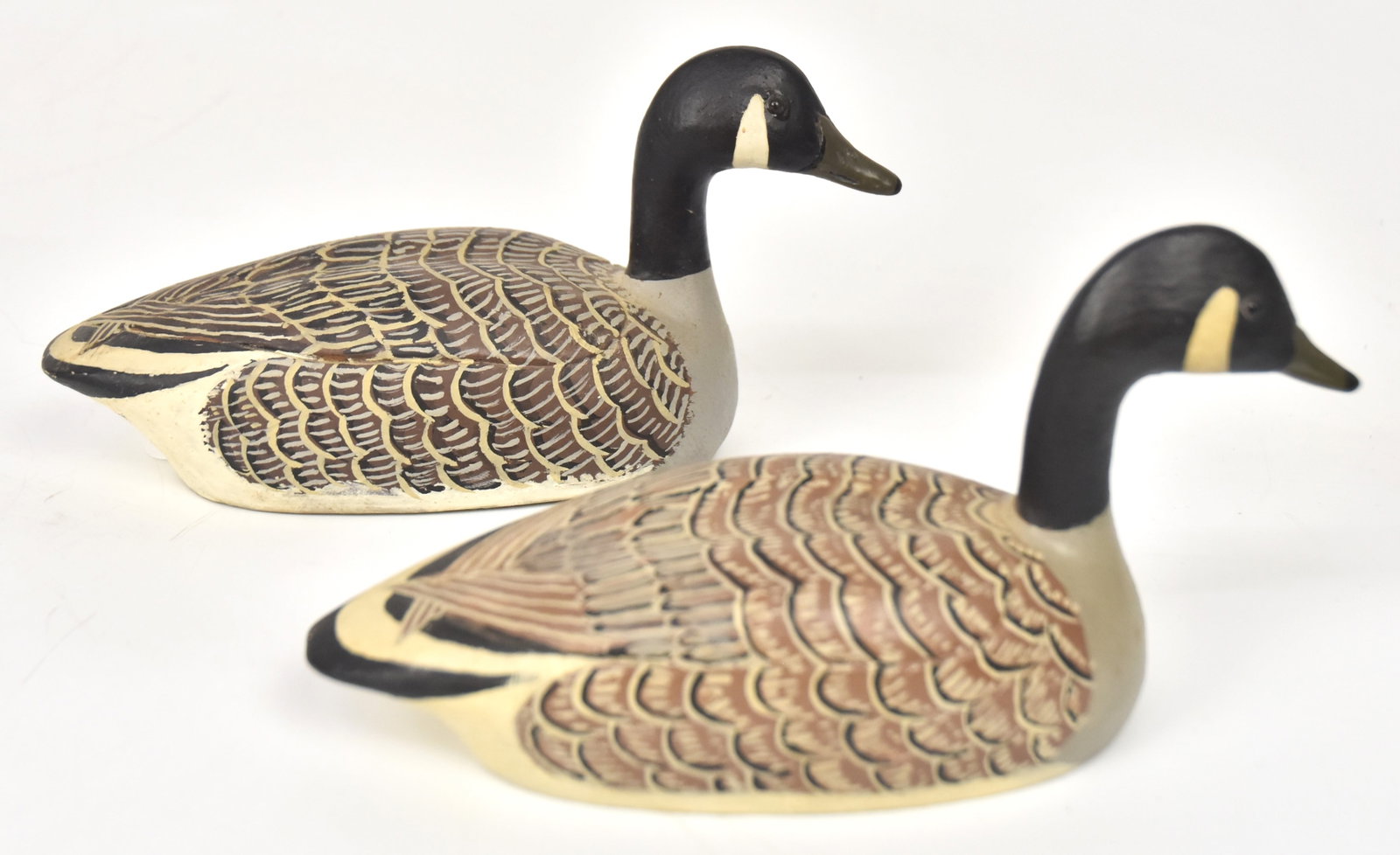 Pr. Of John "Jack" F. Rider, Ohio Geese Decoys: Pr of carved and painted miniature Canadian geese decoys. One stamped, "Carved by J.F. Rider, Port Clinton, Ohio," and the other labeled. Largest 3 3/4" H x 7". Both good condition.