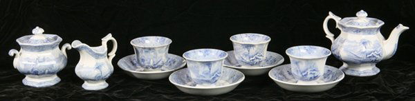 J. HEATH BLUE TRANSFERWARE CHILD'S TEA SET: 19th Century set includes teapot, sugar bowl, creamer, and four cups and saucers. Impressed "J. Heath" on base of saucers. Damaged lids and one saucer has small chip, otherwise fine condition. Teapot