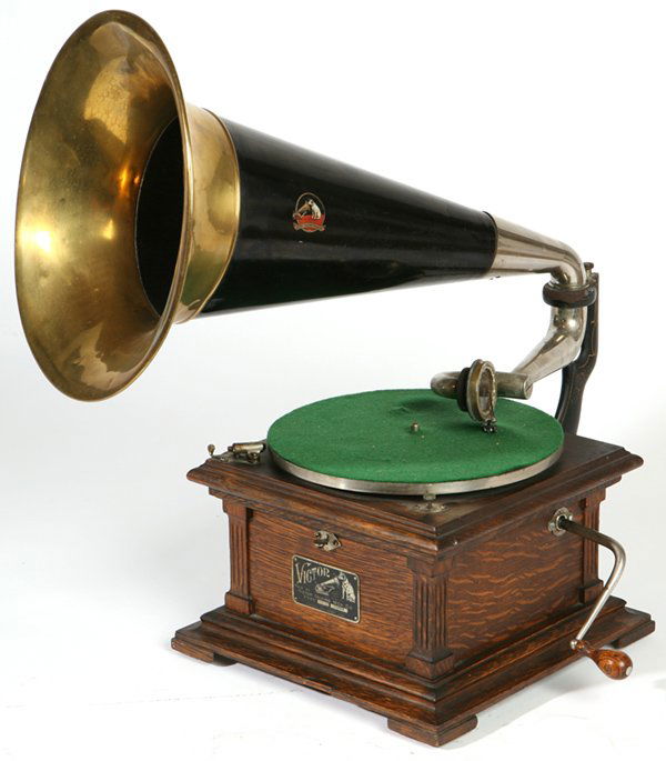 VICTOR II HUMPBACK DISC PHONOGRAPH: Original 20 1/2" black/brass bell horn with decal. Victor exhibition reproducer. Oak case with original finish. Original tag and crank. Fine original phonograph. Good condition.