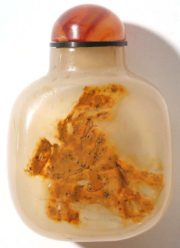CHINESE CARVED CHALCEDONY SNUFF BOTTLE: With the skin carved away leaving a mounted Manchu warrior with banner, agate stopper. Spoon missing, otherwise fine condition. 3" h.