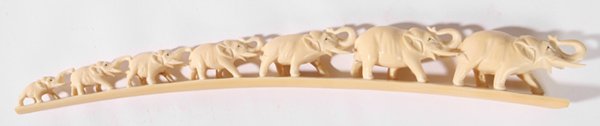 CHINESE CARVED IVORY ELEPHANT BRIDGE: With seven elephants with raised trunks. Leading elephant has left tusk missing. 14" long. THIS LOT CANNOT BE SHIPPED INTERNATIONALLY.
