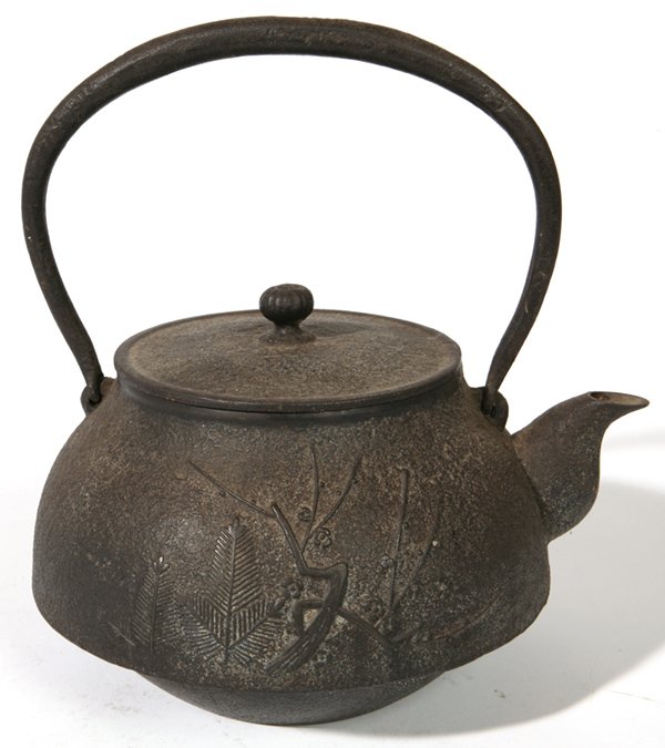 EARLY JAPANESE CAST IRON TEA KETTLE: With low relief stylized cherry branches and ferns, melon finial, and fixed bale handle. Fine old patina. Fine condition. 9" h.