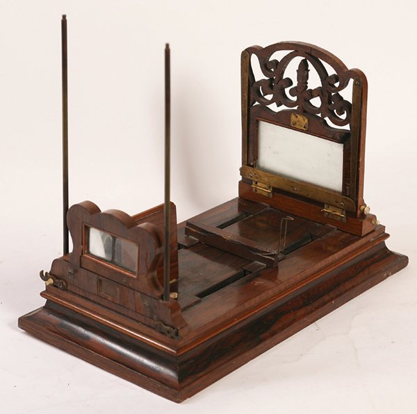 ROSEWOOD TABLETOP STEREO GRAPHOSCOPE: With fold down lens and card holder, ivory knobs and opens to store cards, unmarked, 10” x 18” long, closed it is 3.5” high.