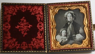 DAGUERREOTYPE PORTRAIT OF ELLEN MCCALLUM & SON: A very fine sixth plate double portrait of Mrs. Ellen Andrew McCallum and her young son Willie, taken in winter, both wearing fine winter clothing and bonnets, lightly tinted cheeks and mounted in ori