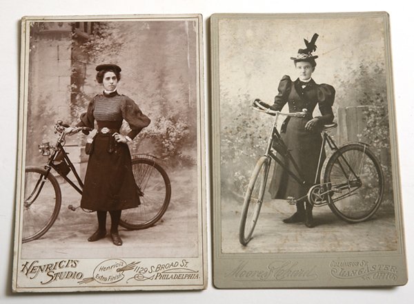 2 CABINET CARD PHOTOS OF EARLY BICYLES: Including one of a young lady wearing bicycling outfit of the period (circa 1900). Her female bike has rear fender, tool kit strapped to central bar, headlight, bell and more, appear quite new with im
