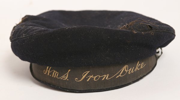WWI SEAMAN CAP BATTLESHIP HMS IRON DUKE: In navy blue wool with embroidered black silk band with “HMS IRON DUKE” on band. The HMS Iron Duke was commissioned in 1912 and was the first in her class.