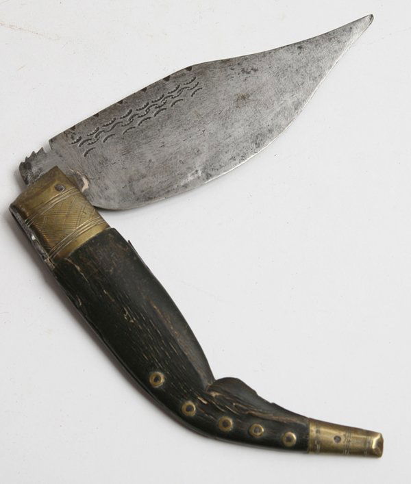 FINE HORN HANDLED EARLY EUROPEAN JACK KNIFE: Of the type used in Southern Europe, hand made with engraved brass mounts, 6.5” single edged steel locking blade with clipped end and engraved geometric designs on each face. Total length when open