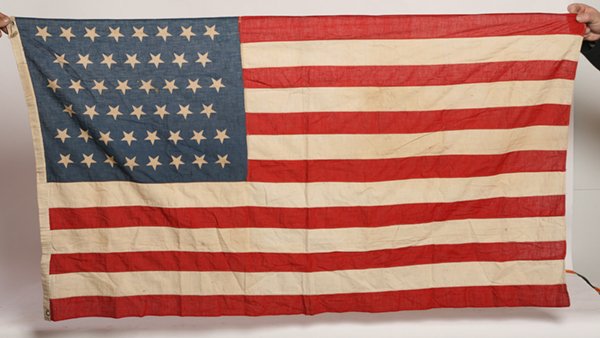 UNUSUAL 50 STAR U.S. PRINTED COTTON FLAG: With canton pattern in 8-7-8-7-8-8, machine sewn stripes and canvas hoist, not the official canton pattern. Two metal grommets in hoist. Inked name on hoist of “Dial”. Found in Batavia, Ohio. 33��