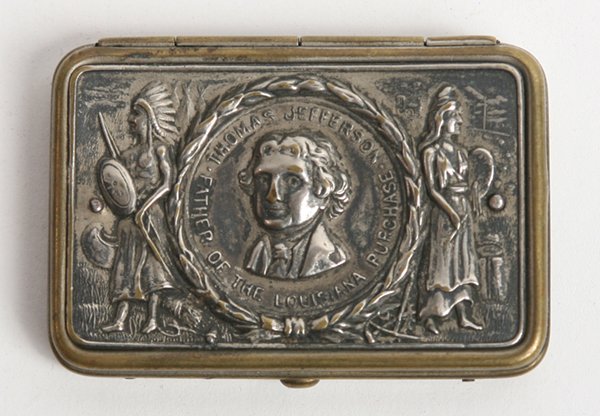 THOMAS JEFFERSON MEMORIAL MATCH SAFE: Silvered brass with stamped bust of Jefferson with laurel wreath surround, flanked by Miss Liberty and Indian with surrounding inscription “Thomas Jefferson Father of Louisiana Purchase”, 1.75” 