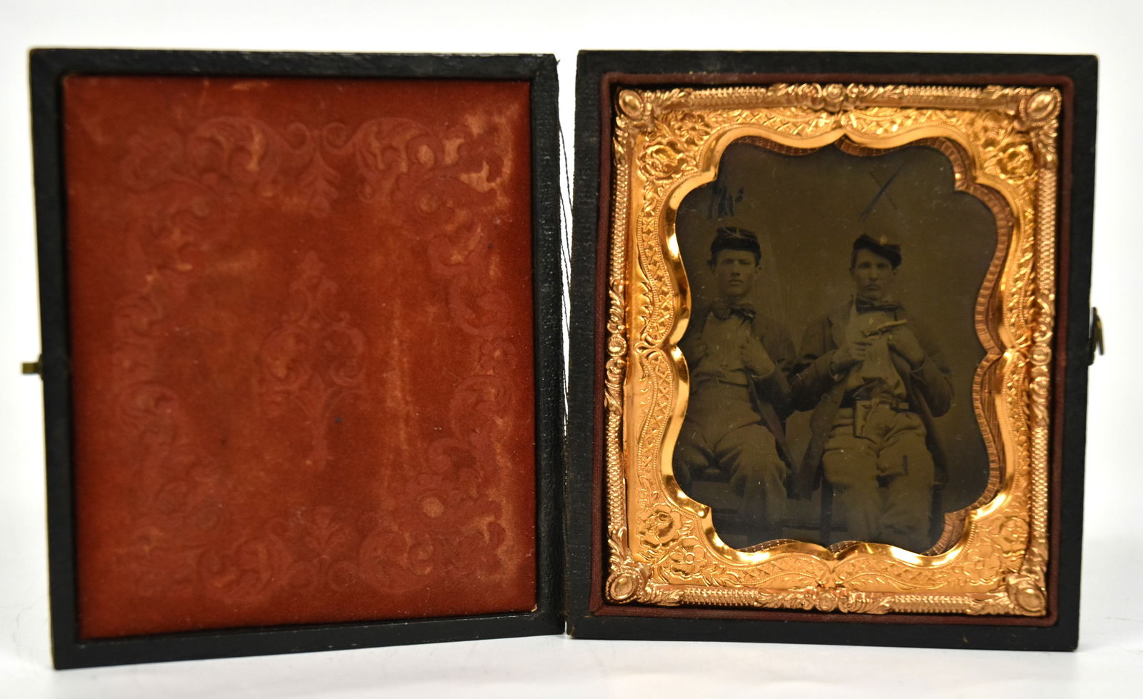 Cased Civil War Tintype of Armed Soldiers: 6th plate with two Union infantrymen seatedwearing kepi, frock coat, shirt and pants, man on right with either a Colt Pocket or Manhatten revolver in right hand with leather holster on his belt, house