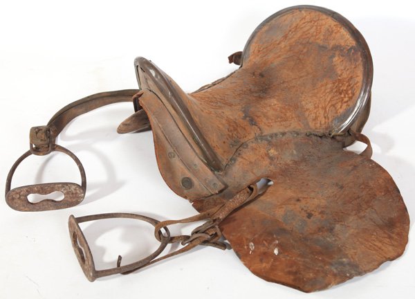 CIVIL WAR CAVALRY SADDLE: In moderately worn brown leather with brass mounts and original cast iron stirrups, 18” long. A private purchase officer type saddle, circa 1862-4.