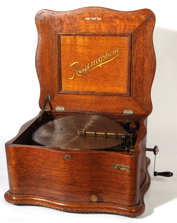 REGINAPHONE 15 1/2" DISC SERPENTINE MUSIC BOX: Double comb with amazing original finish oak case. Complete with turn table, tone arm and horn. 20 discs included. 11" high x 21 1/2" wide x 19" deep.