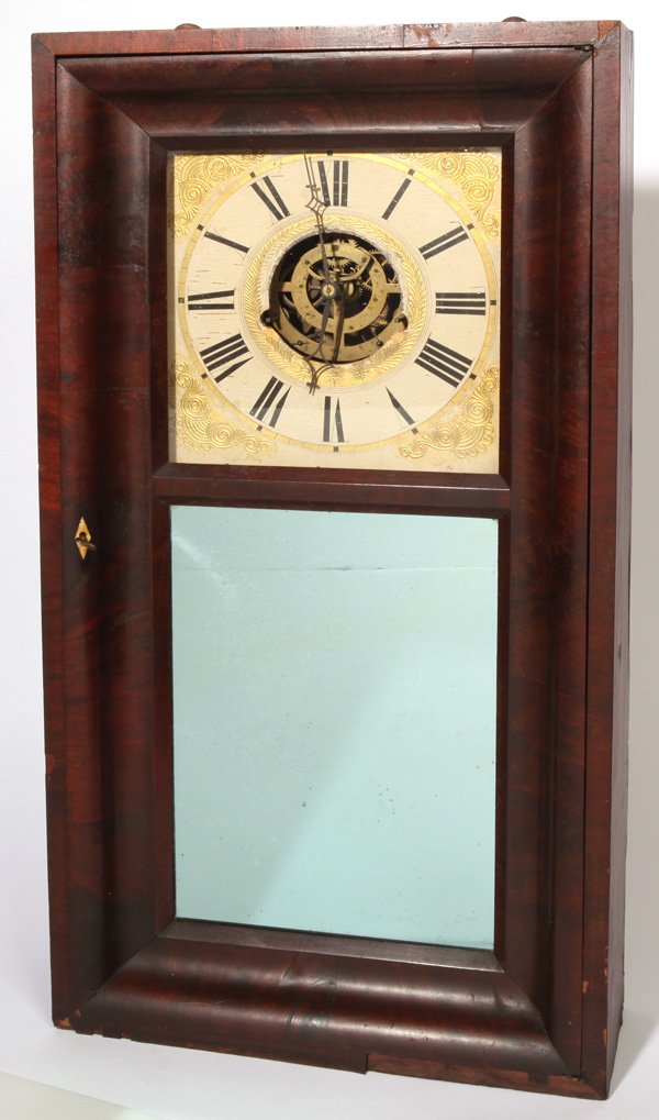 ELI TERRY JR. SCARCE OGEE CLOCK: In mahogany with mirrored door tablet, painted wooden dial with open escapement showing a scarce type of brass 30-hour weight driven time & strike movement, lacking weights, pendulum and key, with ori