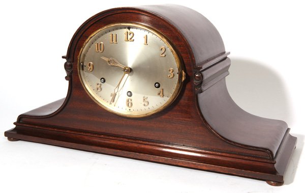 GERMAN CHIMING TAMBOUR SHELF CLOCK: With silvered brass dial with raised brass Arabic numerals, marked “Germany” with “silent” lever along left side and “Trinity & Westm.” Lever along right side of dial, scroll carved mahoga