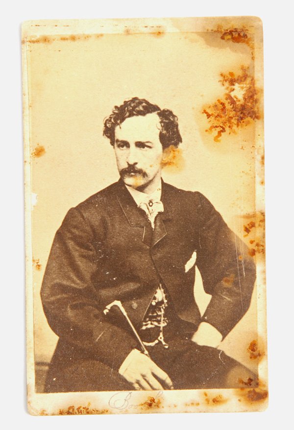 ALBUMEN CDV OF JOHN WILKES BOOTH: A period cdv of booth seated and holding a cane, no backmark but from a Brady negative.