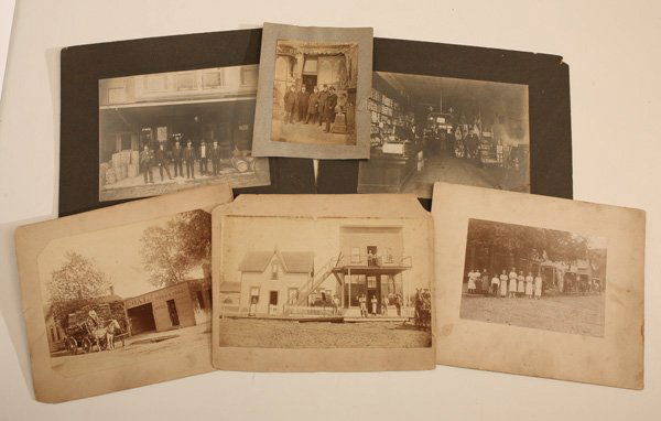 GROUP OF EARLY STORE FRONT & INTERIOR PHOTOS: Lot of 6 including a 4 x 5.25” albumen print on card stock, circa 1870 showing five men in front of tobacco store with wooden cigar store Indian; plus a 6.2 x 8.4” albumen on larger card stock sho