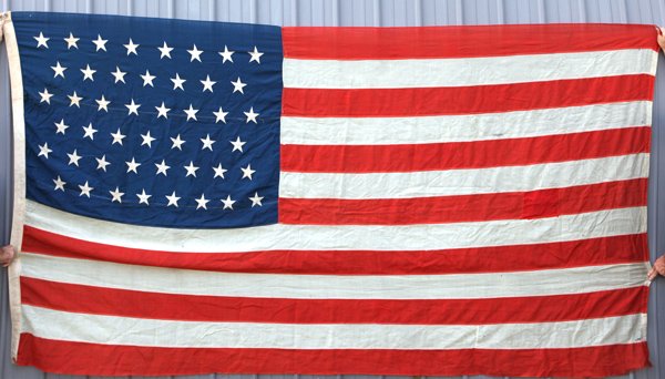 46 Star U.S. Garrison Flag: In wool, early machine sewn with canvas hoist with 2 brass grommets, canton pattern of 8-7-8-7-8-8. Period inked name, "Bullock,” on hoist, 70 x 136”. Oklahoma entered the Union as a state in 1907