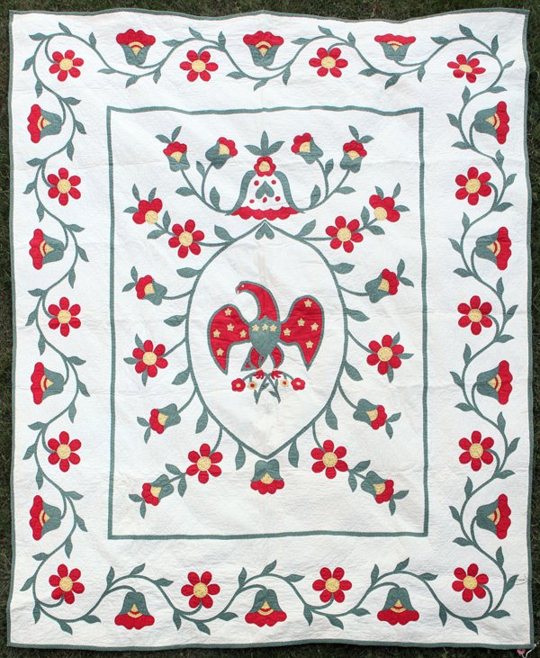 Early Appliqued Eagle Quilt: With spread winged eagle in center having thirteen yellow stats on wings and breast, clutching floral branch in talons with vining floral surround and border, all hand quilted, 78 x 92â€.