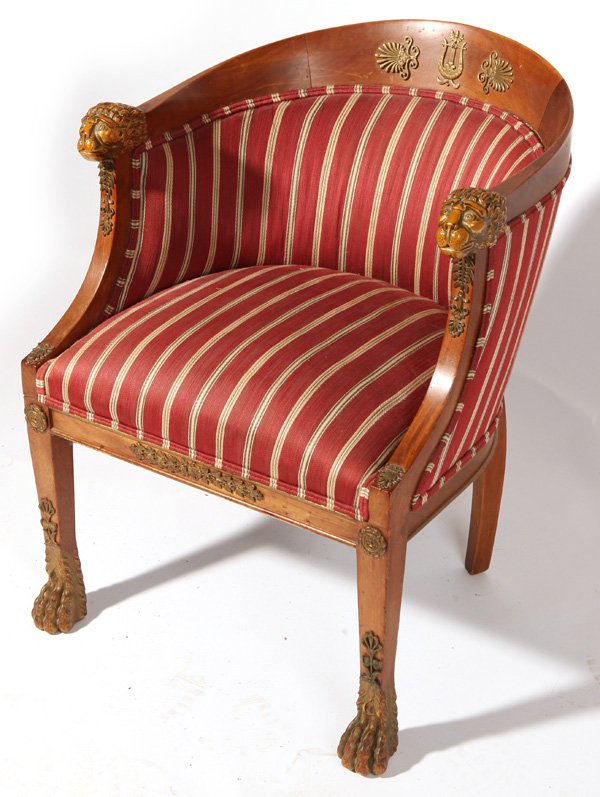 Louis XVI Barrel Back Chair: In mahogany with carved and gilt lion mask arm terminals and feet, ormalu mounts and striped silk upholstery and many ormalu bronze mounts, circa 1900. 22.5" wide x 23" deep x 29" high.