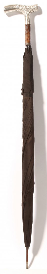 Sterling Handled Edwardian Umbrella: With lovely tau form sterling handle, decorated with flowers and marked with "H" inside a diamond and "Sterling/925/1000" and with engraved date of 1918, with black palm wood below handle and sterling