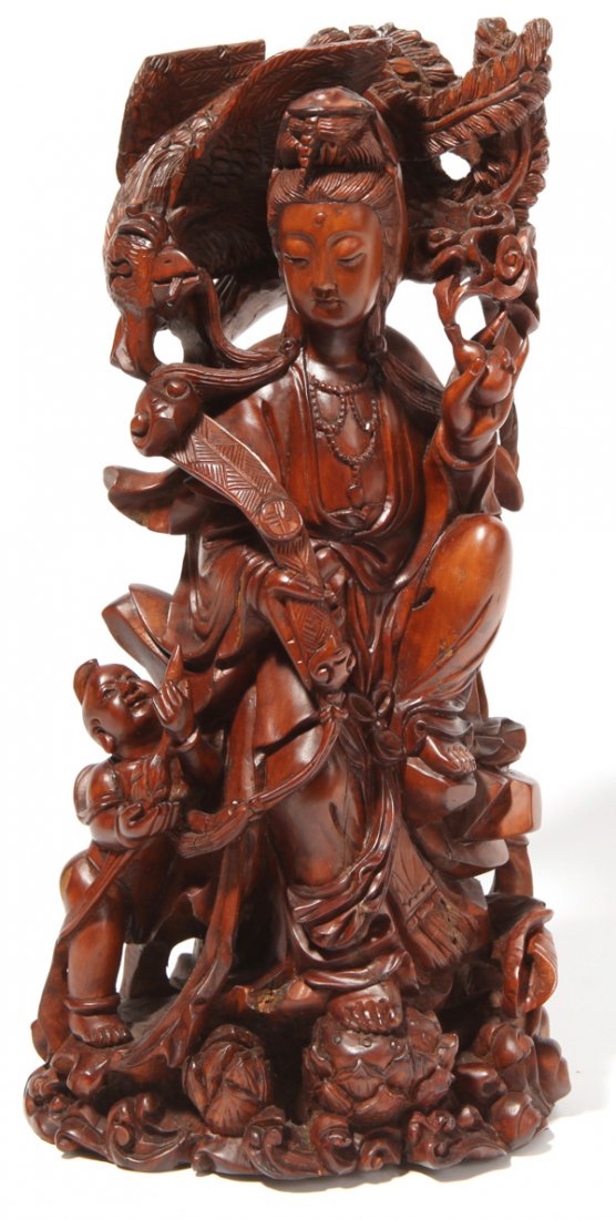 Chinese Carved Fruitwood Buddha: Standing figure in flowing robes, holding a scepter in right hand and flowering branch in left, with phoenix bird above and student at side, 13.5" high.
