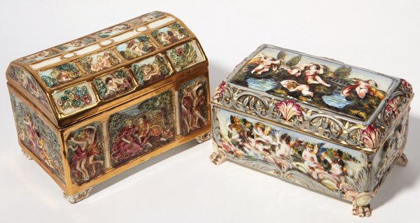 Two Capo Di Monte Jewelery Caskets: One with high relief cheribum on all sides and lid, hand painted in polychrome enamel with gilt highlights, claw feet and hinged lid, 10" x 6" x 6" high. Second with paneled high relief cheribum on do