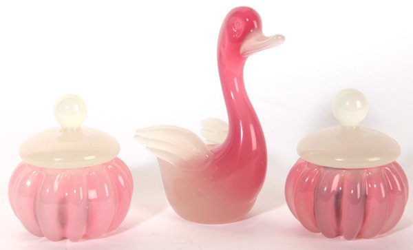 Art Glass Dresser Jars Plus: Lot of three, all in Steuben Rosaline type glass, includes pair of fluted and lidded dresser jars with ground bases, 3.75" x 4.5" high; and spread winged duck figure, 6" x 3.5" x 7" high, also with gr