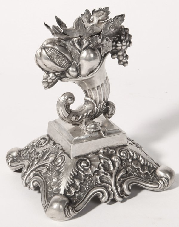 Early Silver Table Ornament: Approximately coin silver grade (.800-.900) chased silver with cornicopia of fruit with top pieced to hold two spiked or stemed objects, possibly flowers, mounted on square plinth on flaired floral an