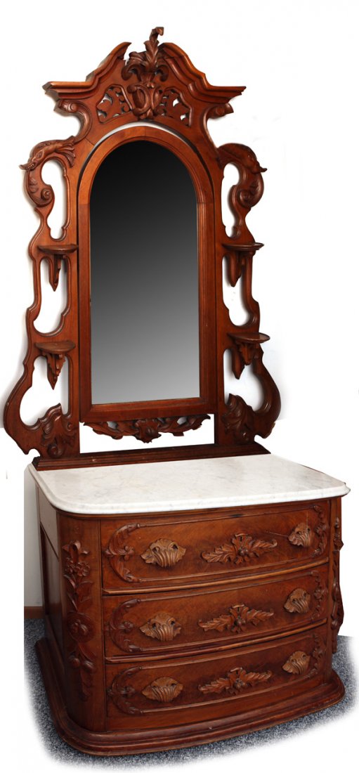 Large Victorian Marble Top Dresser W/Mirror: Attributed to Mitchell & Rammelsburg. Â Walnut with carved pediment at top, center mirror with carved leaves and nuts below, flanked by carved creature heads and double candle holders, all resting o