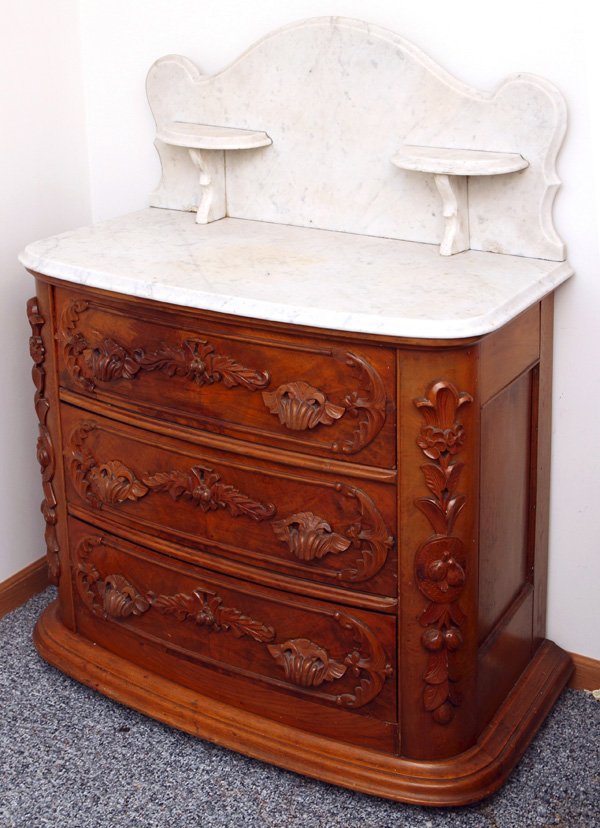 Fine Victorian Marble Top Washstand: Attributed to Mitchell & Rammelsburg. Â High back scalloped marble top with two candle shelves on walnut base with carved nuts and leaves on each side of three carved drawers. Companion to Lot 94A.�