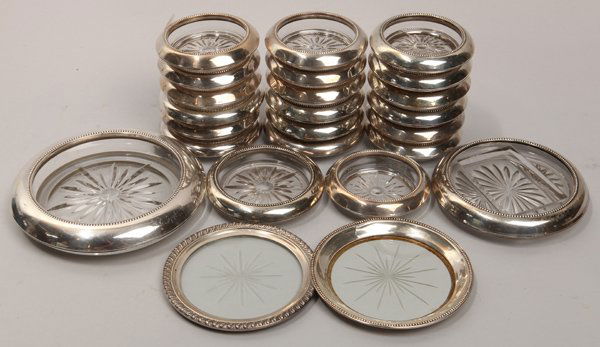 24 Pcs Sterling Coasters: All sterling and glass, including 20 coasters for drinks glasses, two underplates and a coaster for wine bottle, plus another made for a fitted box, possibly for boxed matches, from 4 1/4 to 6 3/4 inc