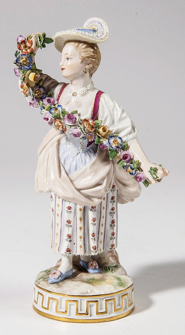 Meissen Figure: Lady with wreath of flowers, blue underglaze crossed sword mark and inscised "F.67." on base, 6 3/4" high.
