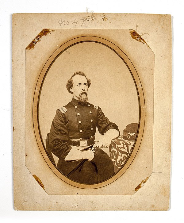 Albumen photo of Col. Charles L. Russell, KIA: A fine 5 1/4 x 7 1/2 inch seated portrait of Charles L. Russel in uniform with double breasted officers frock coat with bird Col. Epaulets, with his kepi on draped table with officers belt and plate a