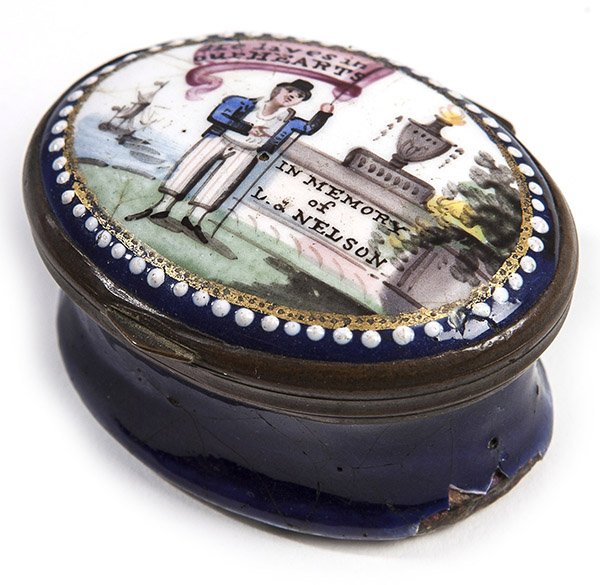 Admiral Nelson Memorial Enameled Patch Box: Battersea type oval enameled patch box with painting on lid of sailor holding flag with inscription reading "He lives in our Hearts" with stone monument to right with inscription "In Memory of L.H. Ne