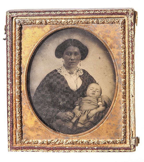 Ambrotype Of African American Nanny & Her White Charge: A quarter plate ambrotype portrait of a young African American Slave holding the white child she is either the nurse-maid too or the nanny of, housed in a half case.