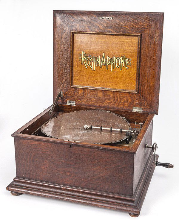 Reginaphone Disc Music Box: Single comb with internal horn. Nice original finish oak case with raised panel top. 22 1/2" W x 20" D x 11 1/2" H.