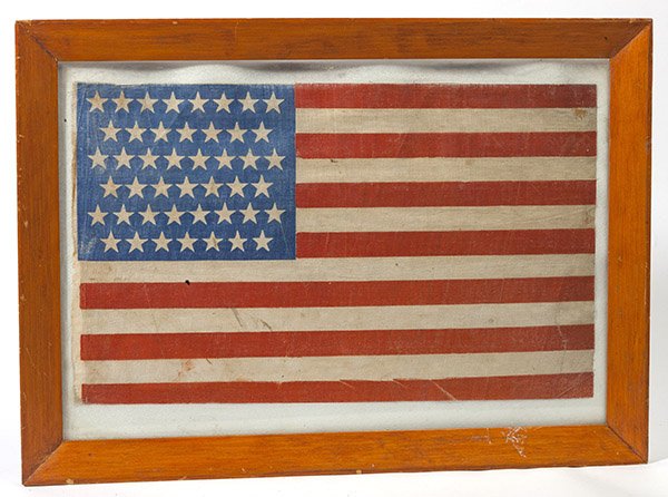 45 Star U.S. Parade Flag: Printed glazed linen with canton pattern of 8-7-8-7-8-7, 10 1/2 x 17 1/2 inches. Pressure mounted on acid free backing and frsmed, 15 x 21 inches.