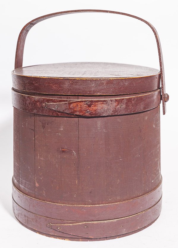 Paint Decorated Firkin: in original old dark red painted finish with single finger banded construction, lidded with swing bale handle attched with turned wood pegs, 12 1/2" diameter x 11 3/4" high, less bale handle.