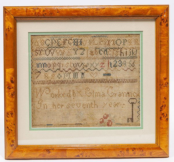 Early American Sampler: with upper and lower case alphobets,, numbers hearts, key, cherries, dog and flowers and signed "Worked By Elma Cranmor In her seventh year.", 8 1/2 x 10" in fine burled walnut frame, 13 1/2 x 15".