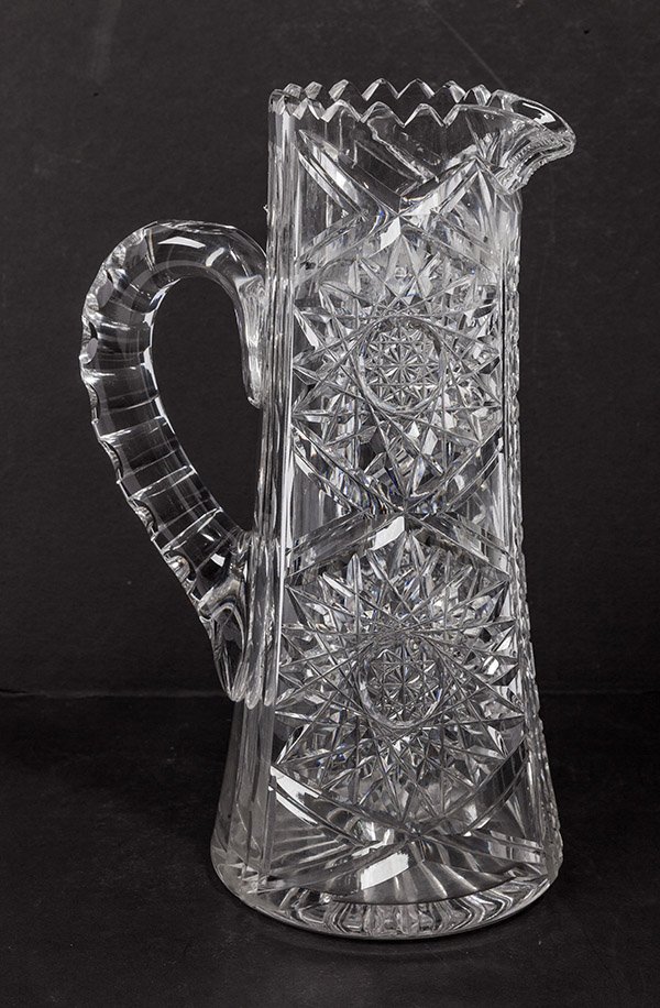 Brilliant Period American Cut Glass Tankard: with hob star cut body, saw tooth lip and coin spot cut handle with star burst base and ladder cut spout, 10 1/4" high.