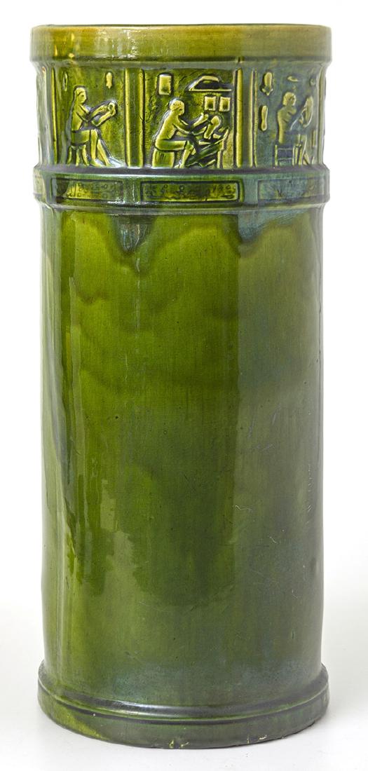 Arts & Crafts Pottery Umbrella Stand: In mottled green glaze with 9 panels at top with different Egyptian Craftsmen with cartouches below with Hyrogliphics, marked with "72" on base. 8 3/4" diameter x 20 1/2" high.