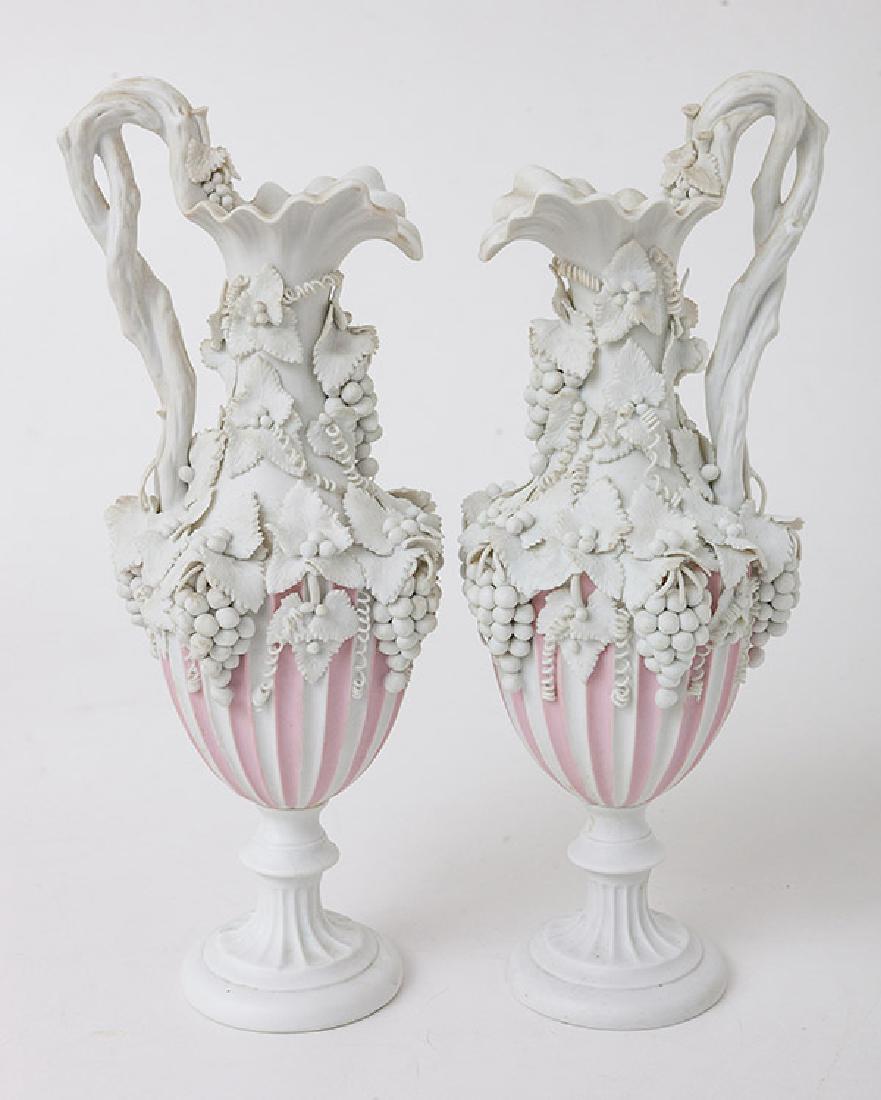 Pair Bennington Parian Ewers: Circa 1880's with wonderfully applied grape vines, leaves and fruit with twisted vine form handles, and fluted lower bodies on fluted pedestaled bases, with pink banding on upper fluting. Marked on ba