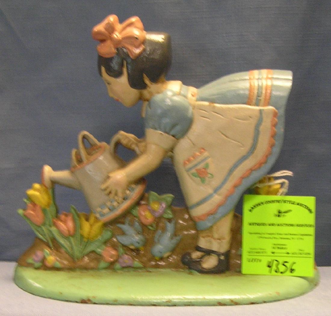 Hand painted cast iron girl watering flowers door stop: Hand painted cast iron girl watering flowers door stop circa 1960’s $150.00-$200.00