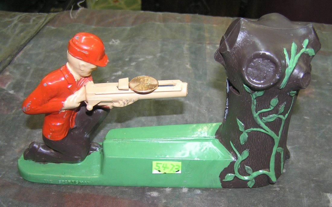 Vintage Sportsman mechanical shooting coin bank: Vintage Sportsman hand painted cast metal mechanical shooting coin bank with original coin trap bank is in excellent condition less squirrel target in tree, gun still fires well $100.00-$125.00