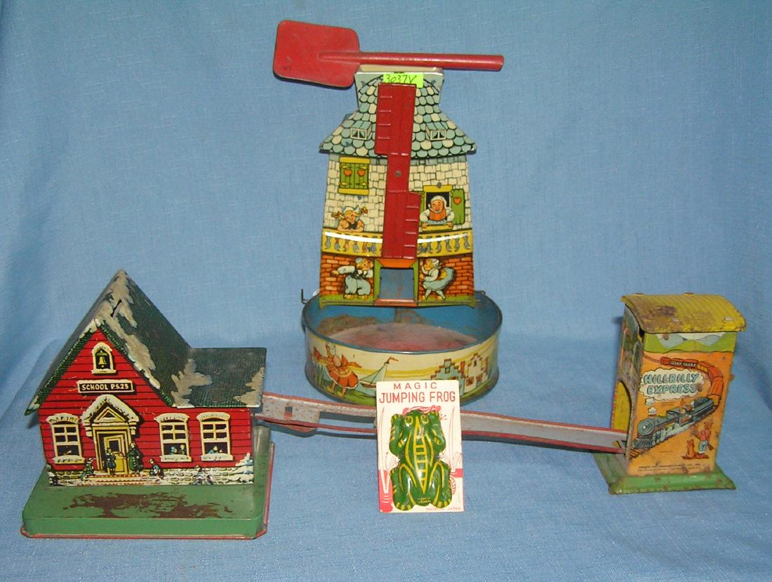 Group of early tin toys: Group of early tin toys includes a great antique wind mill sand toy and shovel, school house bank, Hill Billy express toy and tin magic jumping frog on card est. value $125.00-$150.00