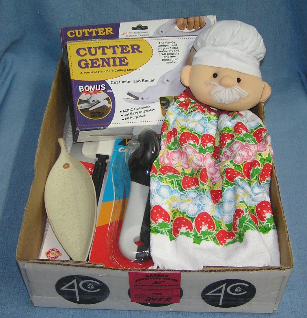Box full of new products: Box full of new products includes Cutter Genie, scissors, leaf shaped dish, pair of wonderful can openers as seen on TV, Farberware 2 piece spatula set, new table cover, chef themed puppet style kitch