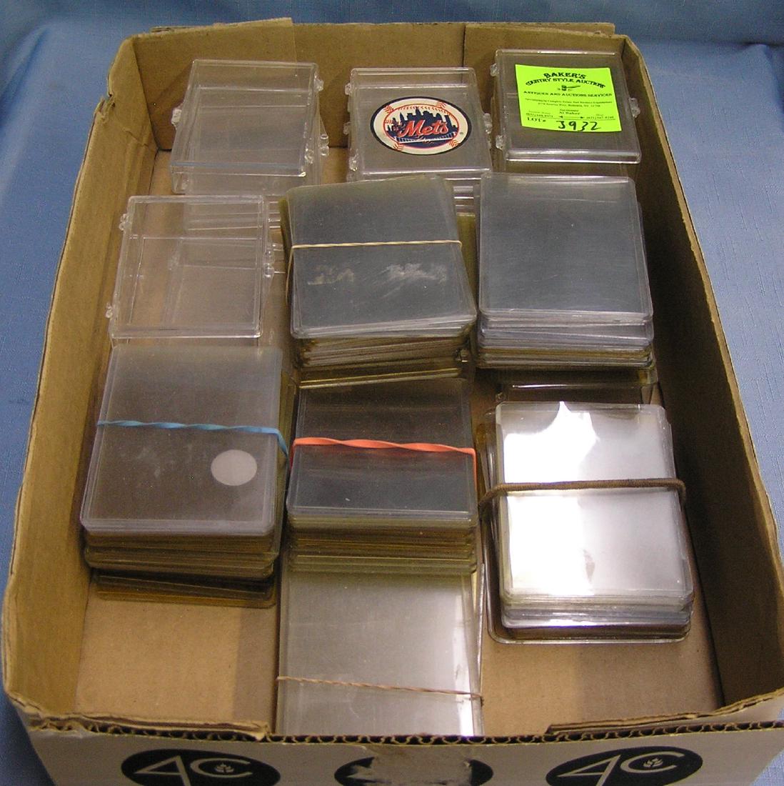Box full of trading card protective cases and sleeves