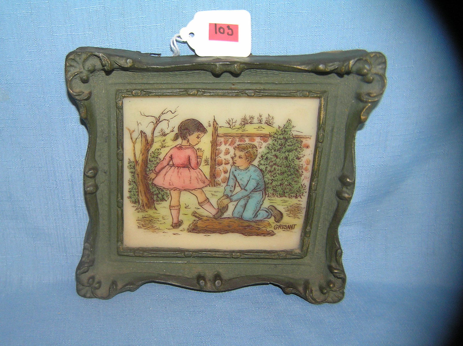 Artini engraving young boy tying a young girl's shoe: Artini engraving featuring a young boy tying a young girl's shoe with scenic background artist signed Grisant mounted and framed with original tag on back marked genuine Artini hand painted engraving