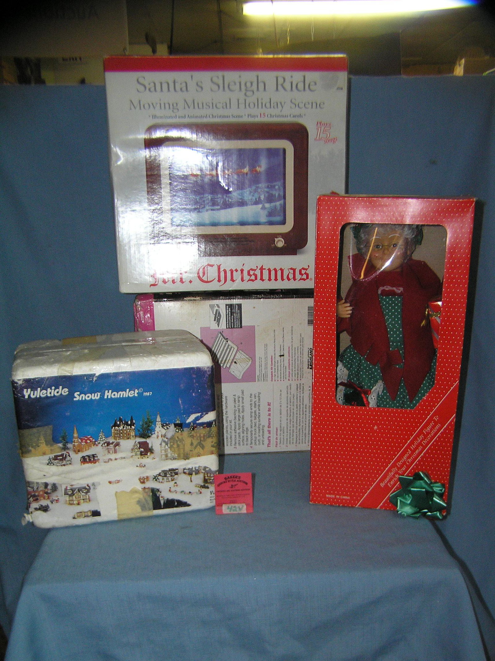 Group of quality Christmas decorations: Group of quality Christmas decorations includes illuminated and mechanical santa's sleigh ride moving musical holiday scene that plays 15 songs, 16 inch battery operated Mrs. Claus figure and a Yultid